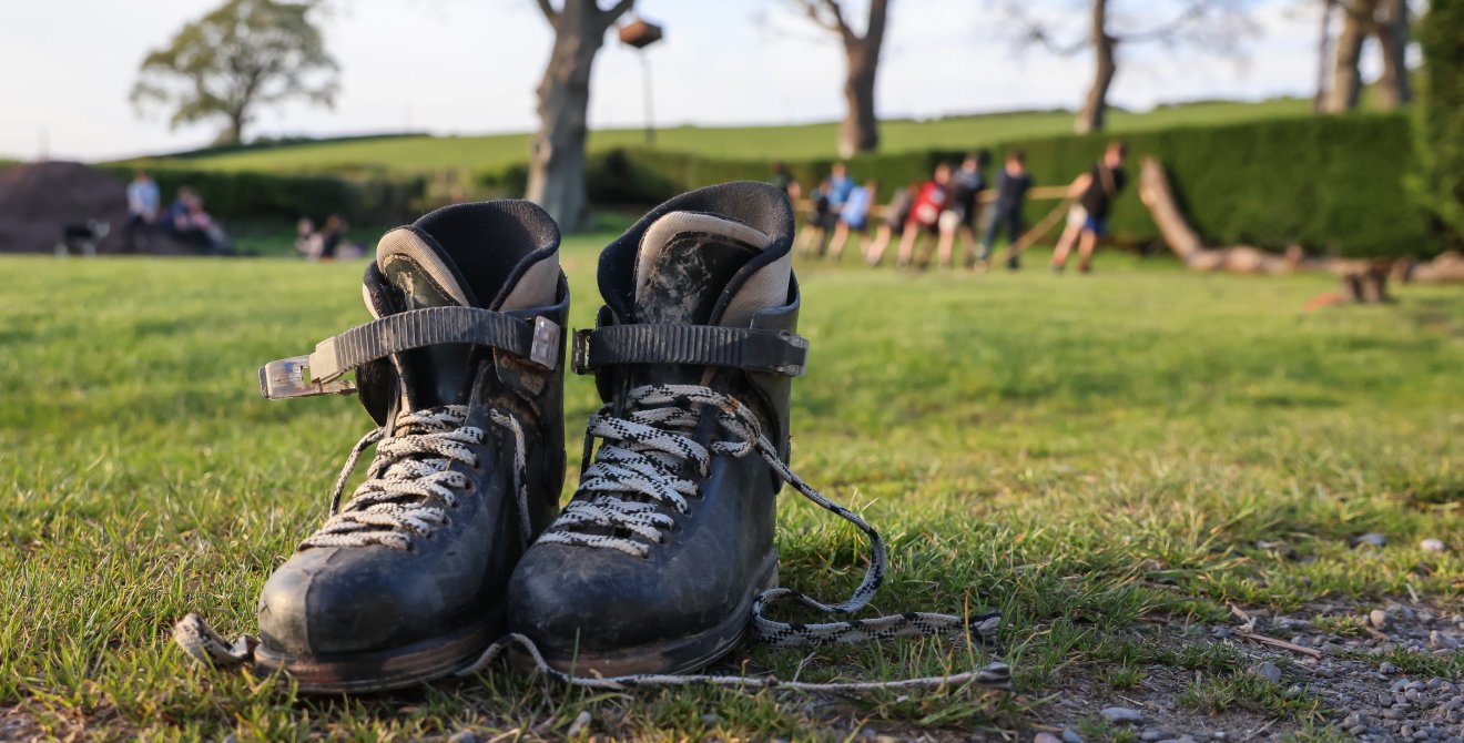 A pair of dark boots on a muddy field