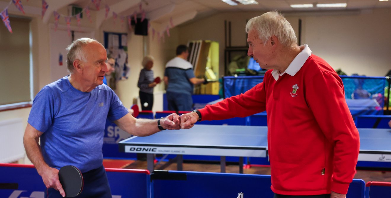 Andy fist bumps a team mate by the table