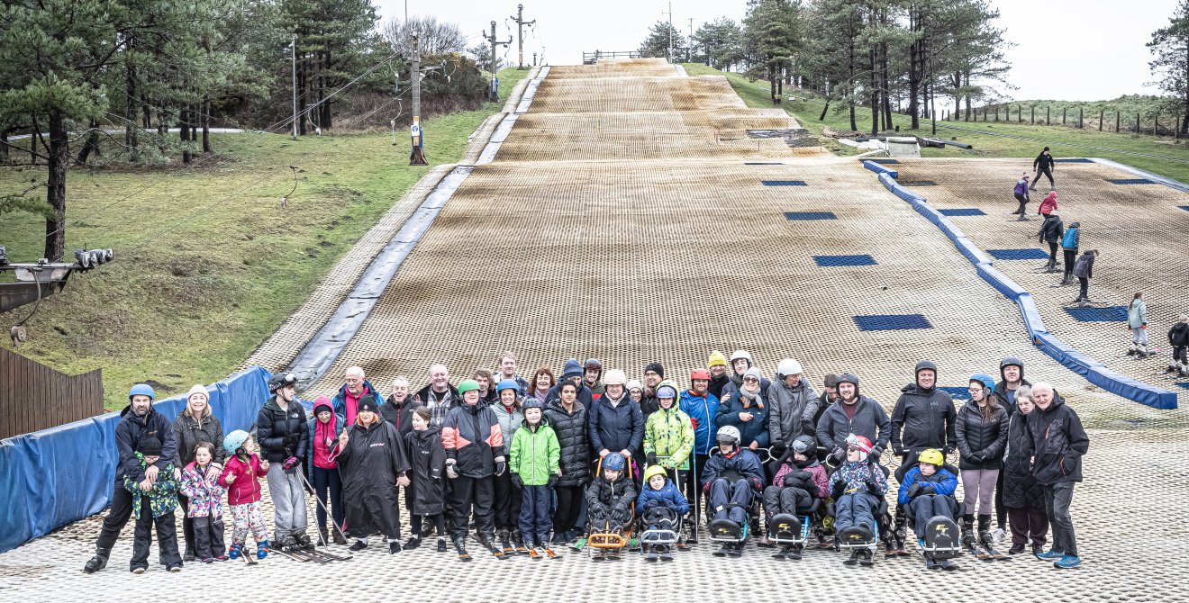 The group of skiers pose for a photo on the slope