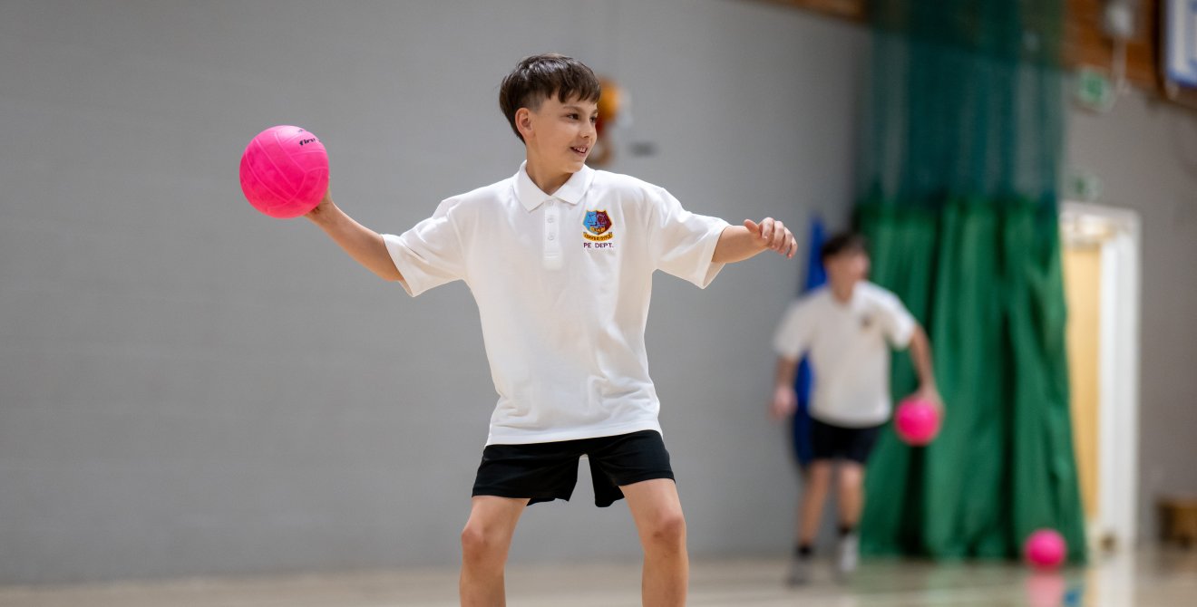 A boy playing dodgeball.