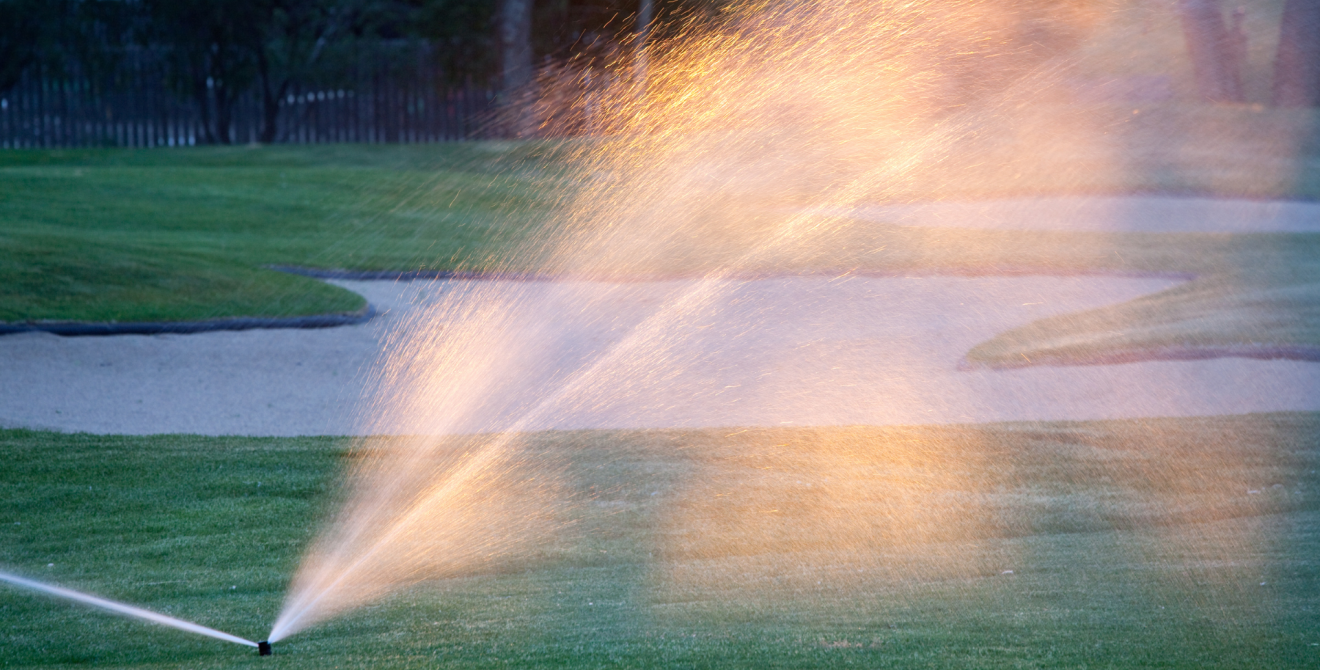 A sprinkler watering a golf course