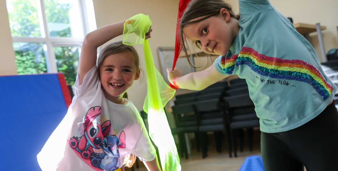 Children waving colourful ribbon in a gymnastics class.