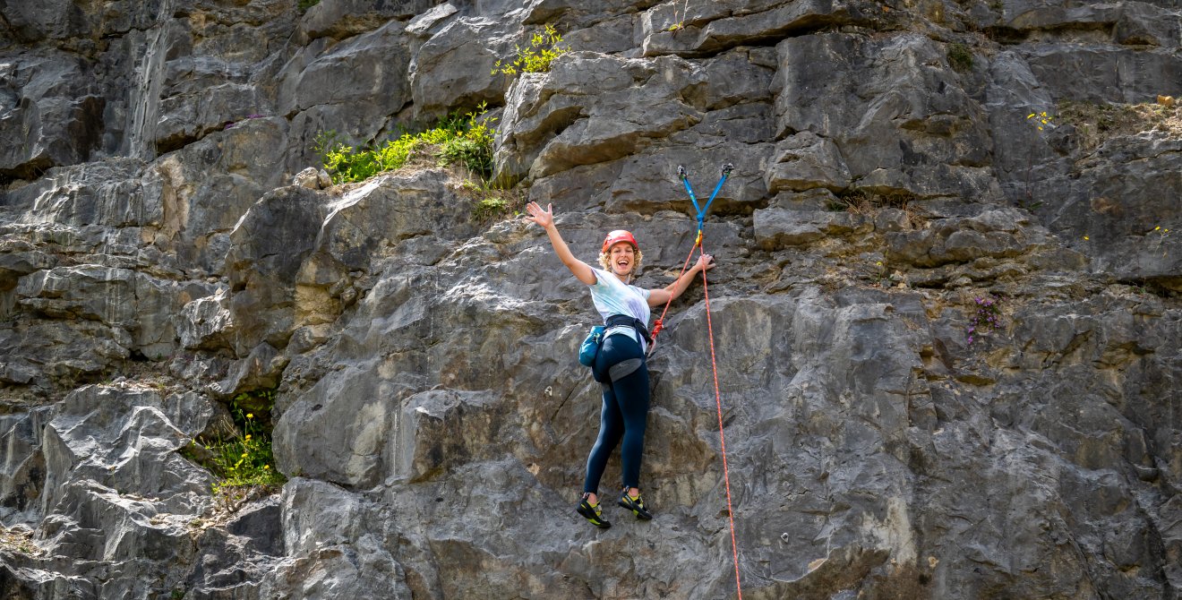 Hannah waving from the climbing wall.
