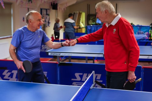 Andy fist bumps a team mate by the table