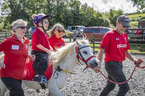 Iori on a horse, supported by volunteers