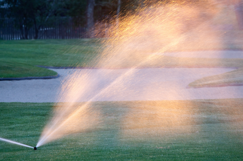 A sprinkler watering a golf course