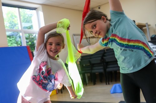 Children waving colourful ribbon in a gymnastics class.