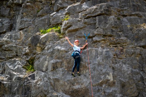 Hannah waving from the climbing wall.