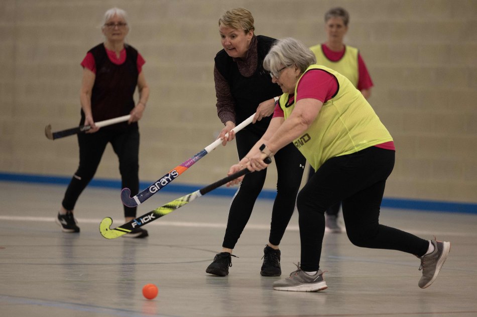 Women playing walking hockey together.
