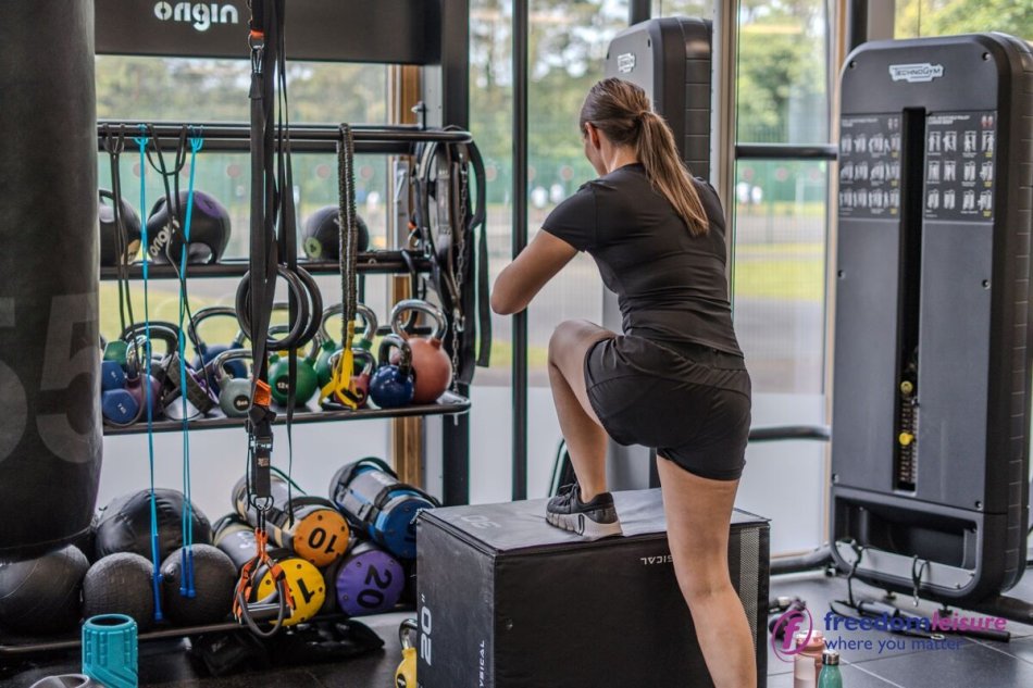 Menyw yn ymarfer corff yn y gampfa