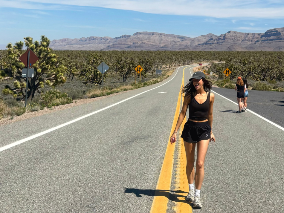 Gwenno stood on a road with mountains in the background.