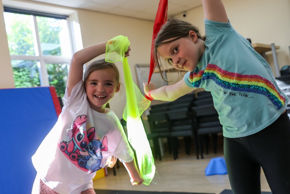 Children waving colourful ribbon in a gymnastics class.