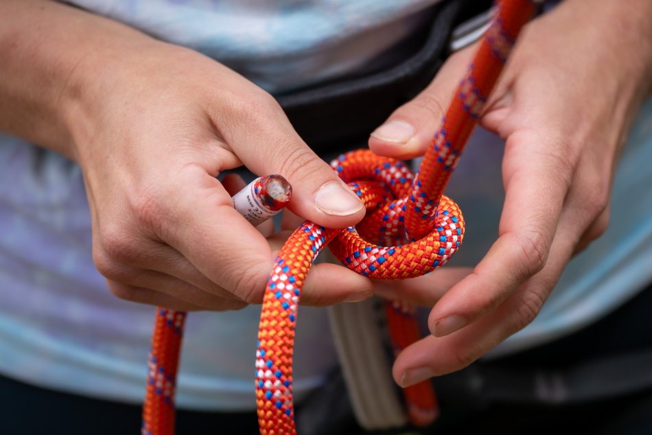 Hannah tying the climbing rope to her harness.
