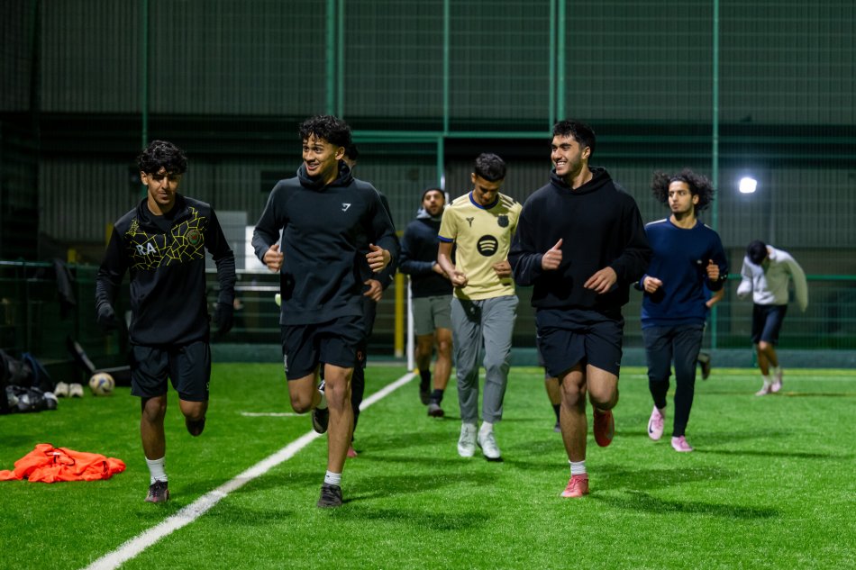 A group of men running across a football pitch